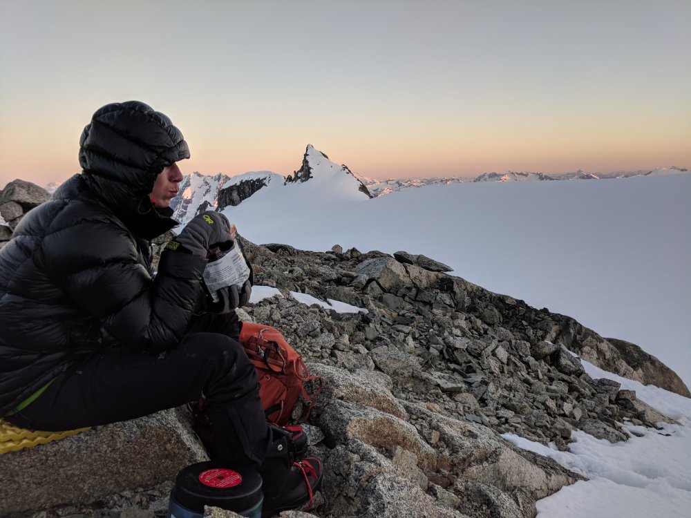 Jake, eating dinner with sunset over inspiration glacier